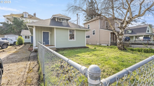 view of front of property featuring board and batten siding, roof with shingles, a front yard, and fence