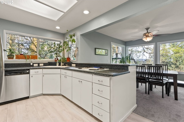 48 Eagle Crest Dr Unit 2E, Lake Oswego, OR 97035 - kitchen with a sink, dishwasher, white cooktop, a peninsula, and white cabinetry