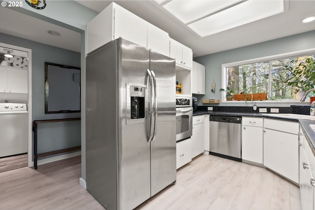48 Eagle Crest Dr Unit 2E, Lake Oswego, OR 97035 - kitchen featuring stainless steel appliances, a sink, light wood-style floors, white cabinetry, and washer / clothes dryer