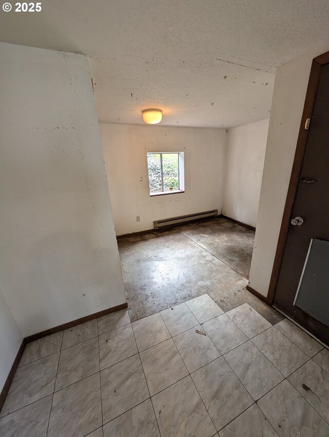 10539 NW 3rd St, Portland, OR 97231 - unfurnished room featuring a baseboard radiator, a textured ceiling, and baseboards