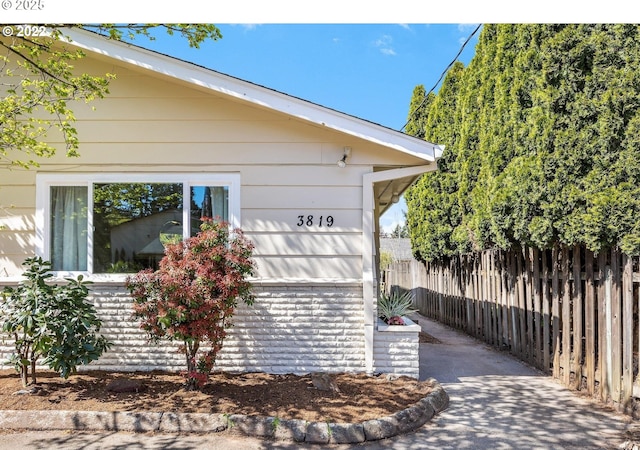 view of side of home featuring fence