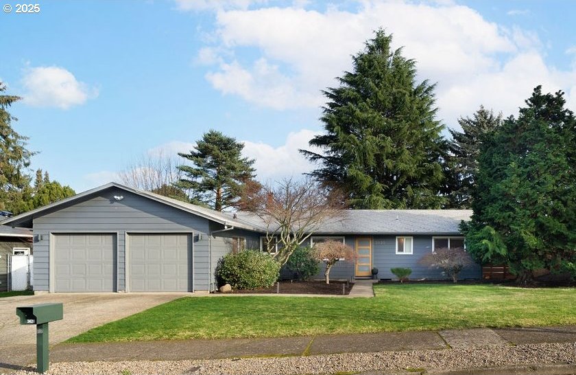 single story home featuring a front yard and a garage