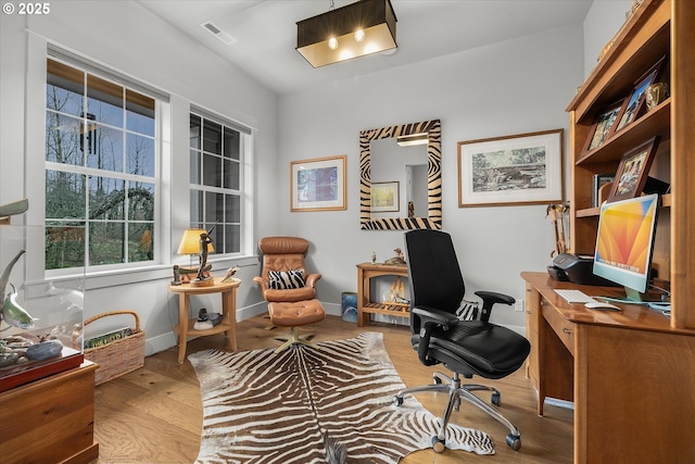 office area featuring visible vents, baseboards, and wood finished floors