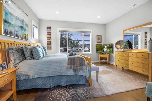 bedroom with recessed lighting, wood finished floors, visible vents, and baseboards