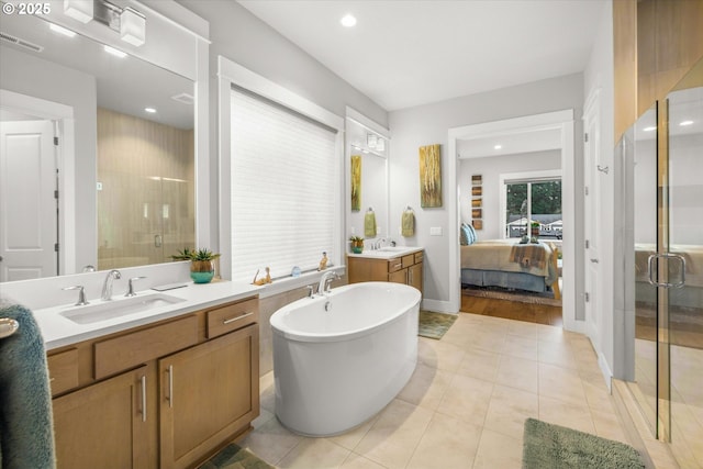 ensuite bathroom featuring visible vents, a soaking tub, two vanities, a sink, and a shower stall