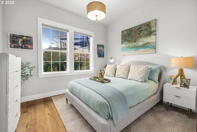 bedroom with baseboards and wood finished floors