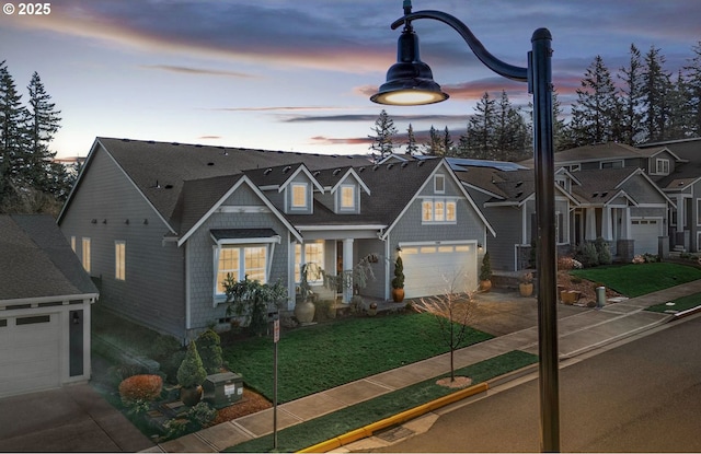 view of front of property with a residential view, an attached garage, concrete driveway, and a yard