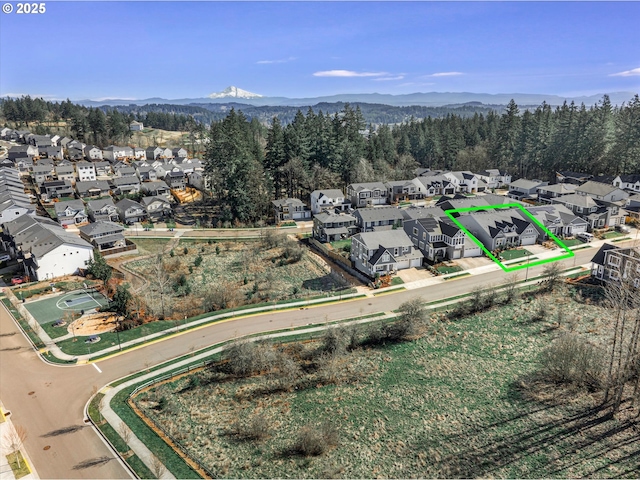 bird's eye view featuring a residential view, a mountain view, and a wooded view