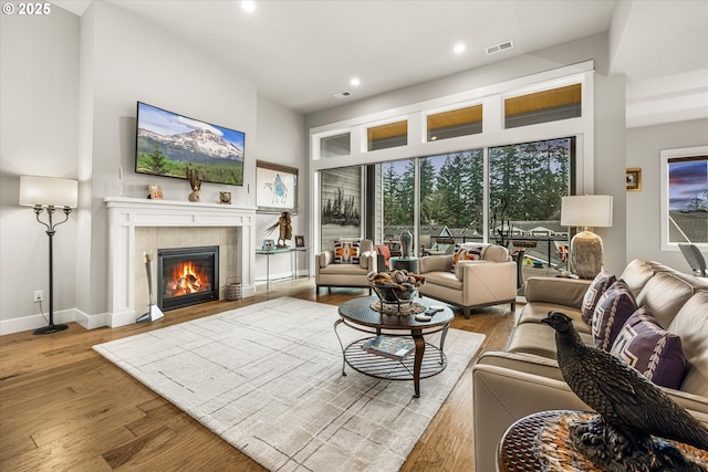 living area featuring visible vents, wood finished floors, recessed lighting, a fireplace, and baseboards