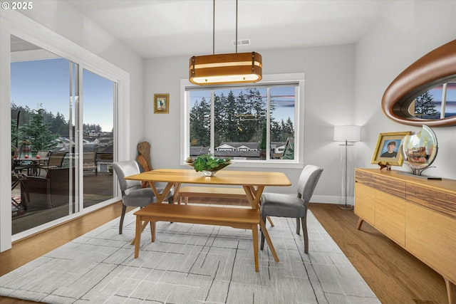 dining room featuring visible vents, baseboards, and wood finished floors