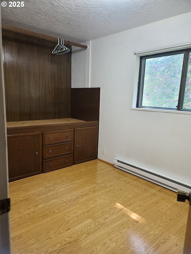 902 Coal Creek Rd, Longview, WA 98632 - unfurnished room with baseboard heating, a textured ceiling, and wood finished floors