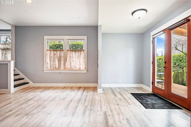 foyer entrance with a healthy amount of sunlight, french doors, and wood finished floors