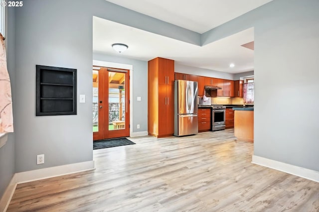 kitchen featuring dark countertops, light wood-type flooring, baseboards, and stainless steel appliances