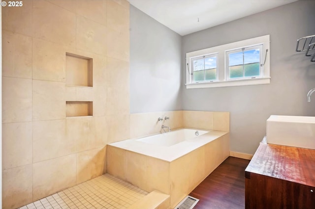 bathroom featuring visible vents, vanity, a garden tub, and wood finished floors