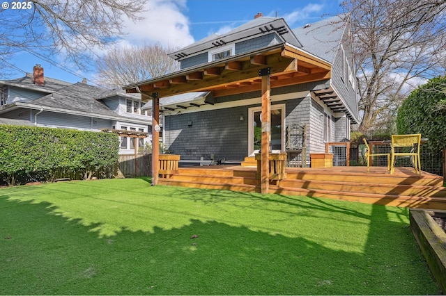 rear view of house featuring french doors, a lawn, a wooden deck, and fence