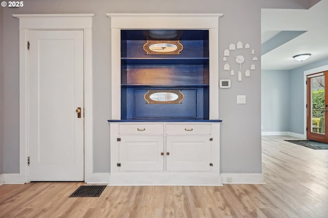 interior space featuring wood finished floors, visible vents, and baseboards