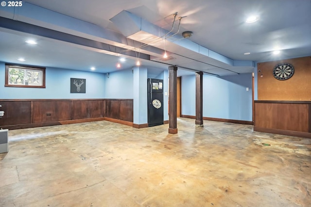 basement with elevator, wainscoting, and wood walls