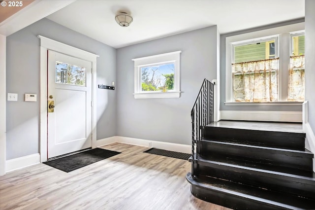 foyer featuring stairway, wood finished floors, and baseboards