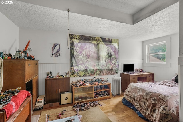 307 Columbia St, Kelso, WA 98626 - bedroom with a textured ceiling, radiator, a wainscoted wall, and wood finished floors