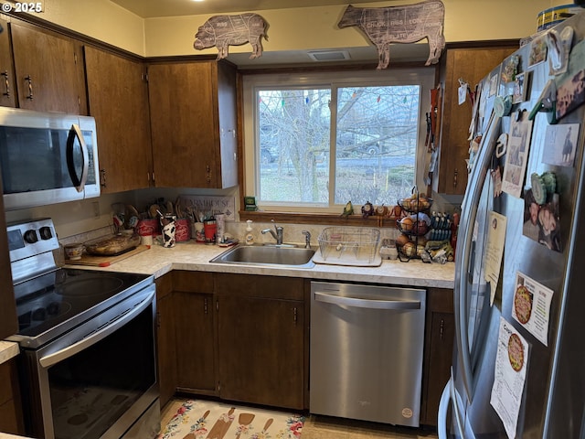 76984 Palmer Junction Rd, Elgin, OR 97827 - kitchen featuring visible vents, appliances with stainless steel finishes, dark brown cabinets, a sink, and light countertops