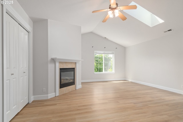 2795 Mallory Ln, Eugene, OR 97401 - unfurnished living room with light wood-style flooring, lofted ceiling, a tiled fireplace, a ceiling fan, and baseboards