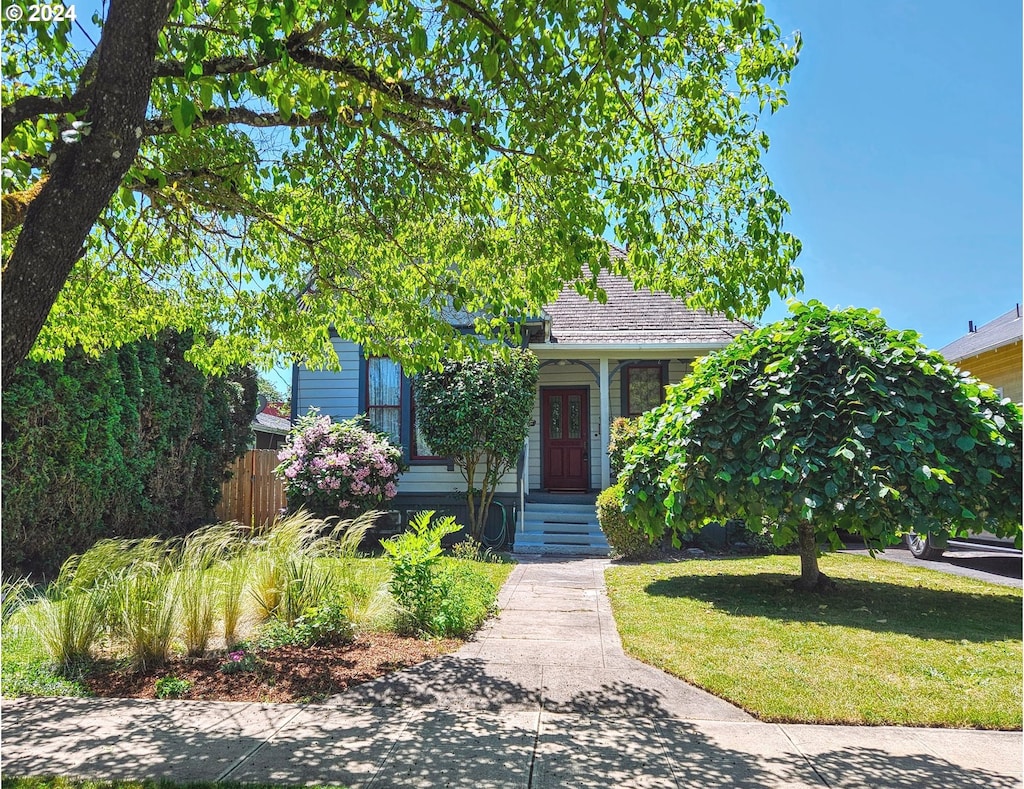 view of property hidden behind natural elements featuring a front yard