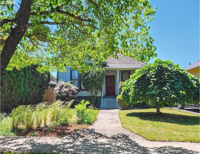 view of property hidden behind natural elements featuring a front yard