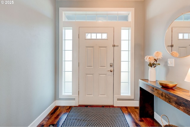 foyer entrance with dark wood-type flooring and baseboards