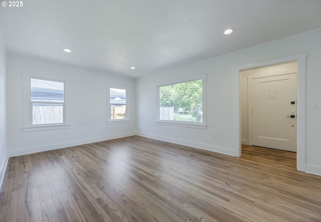 spare room featuring light wood-style floors, baseboards, and recessed lighting
