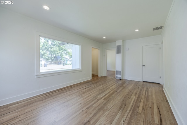 unfurnished bedroom featuring a heating unit, crown molding, light wood-style flooring, baseboards, and recessed lighting
