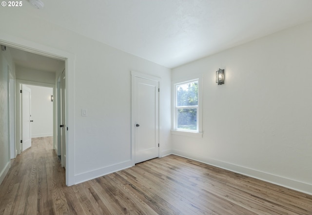 unfurnished bedroom featuring wood finished floors and baseboards