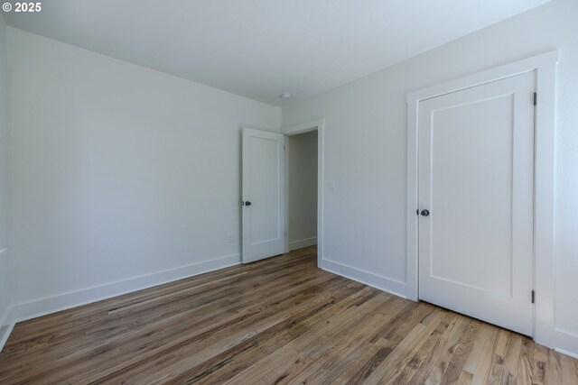 unfurnished bedroom featuring wood finished floors and baseboards