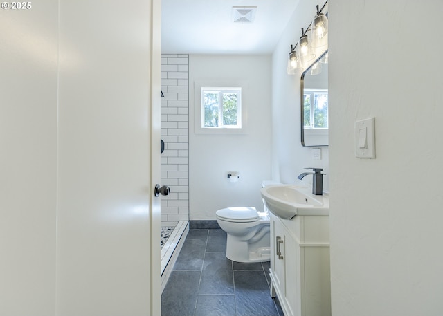 bathroom featuring toilet, a stall shower, vanity, tile patterned floors, and baseboards