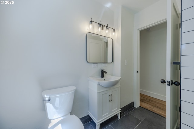 bathroom with tile patterned floors, toilet, vanity, and baseboards