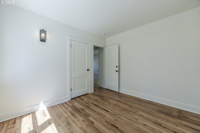 unfurnished room with baseboards and wood finished floors