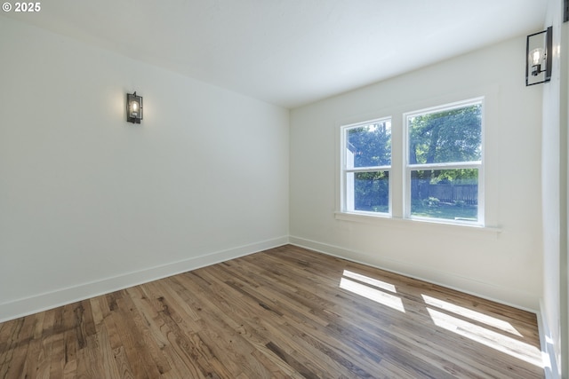 spare room featuring wood finished floors and baseboards