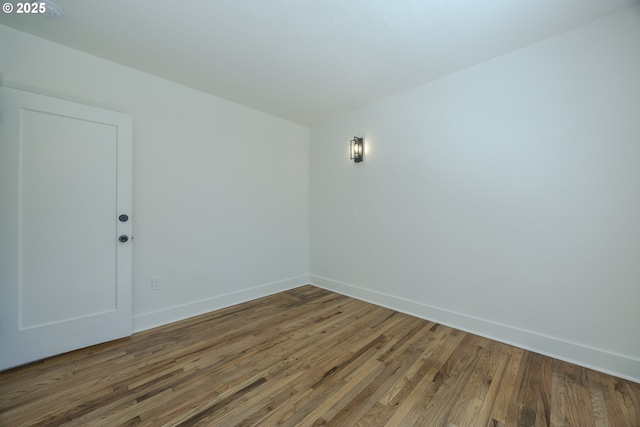 empty room featuring wood finished floors and baseboards