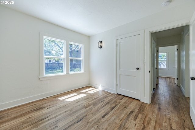 spare room with a smoke detector, wood finished floors, and baseboards