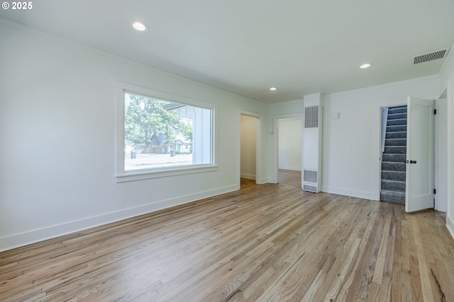 unfurnished bedroom with crown molding, a heating unit, light wood finished floors, baseboards, and recessed lighting