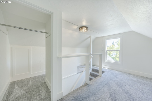 walk in closet with carpet and vaulted ceiling