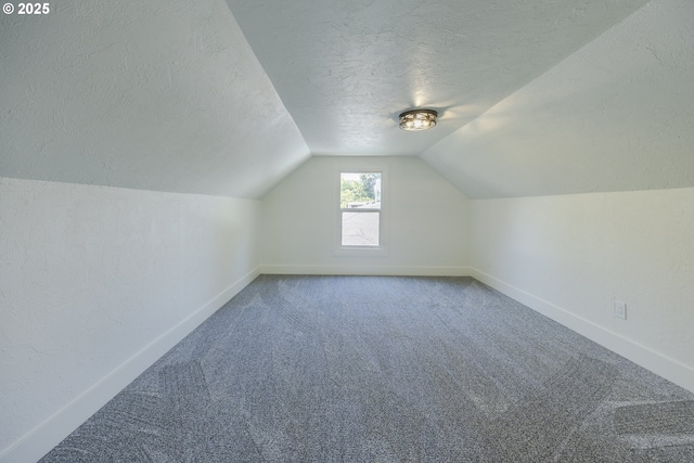 bonus room with a textured ceiling, carpet floors, lofted ceiling, and baseboards