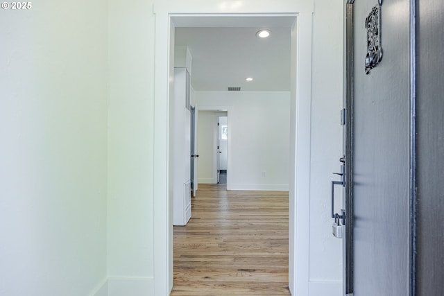 hall featuring light wood-style floors, baseboards, recessed lighting, and ornamental molding
