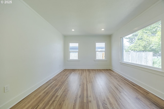 empty room featuring baseboards, light wood-style floors, and recessed lighting