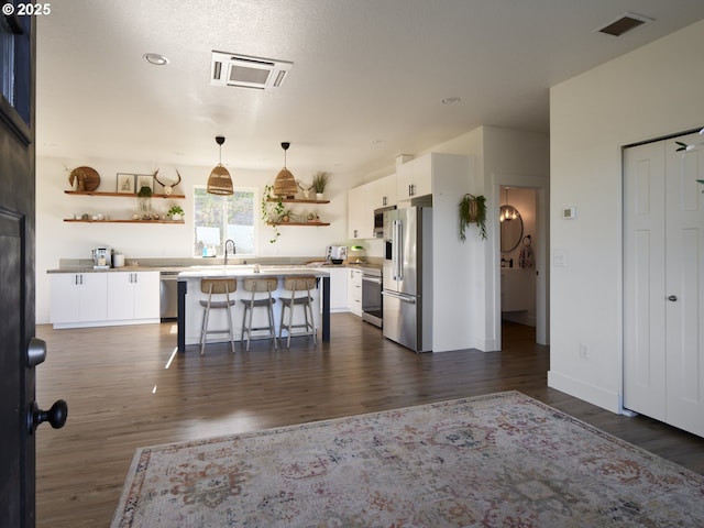 159 Bootjack Ln, Rose Valley, WA 98626 - kitchen featuring open shelves, white cabinetry, a kitchen breakfast bar, and dark wood-style floors