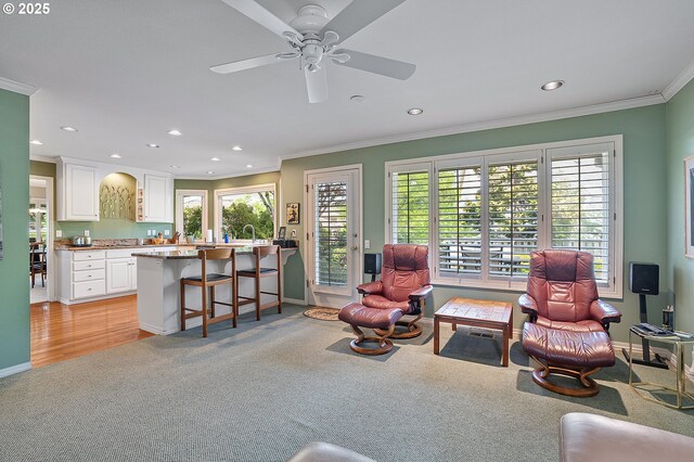 living room featuring light carpet, crown molding, recessed lighting, baseboards, and ceiling fan