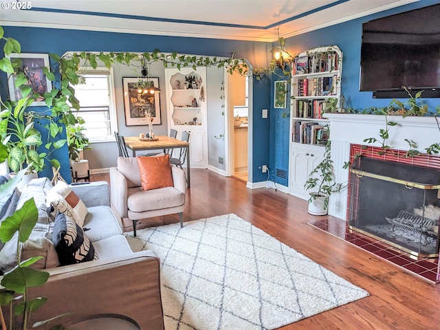 4621 NE 37th Ave, Portland, OR 97211 - living room with a chandelier, a fireplace with flush hearth, wood finished floors, crown molding, and baseboards