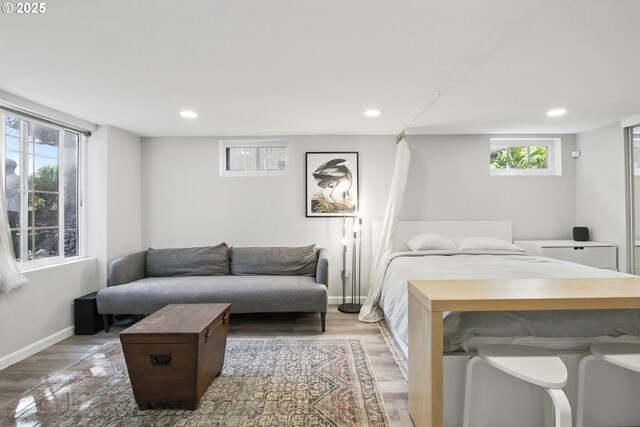 bedroom featuring wood finished floors, recessed lighting, and baseboards