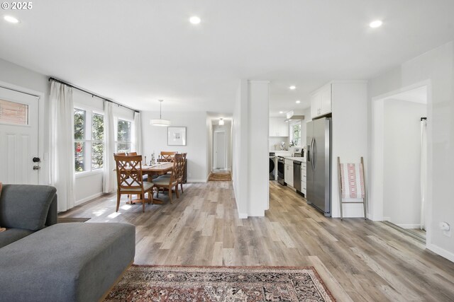 living area with light wood-style flooring, recessed lighting, and baseboards