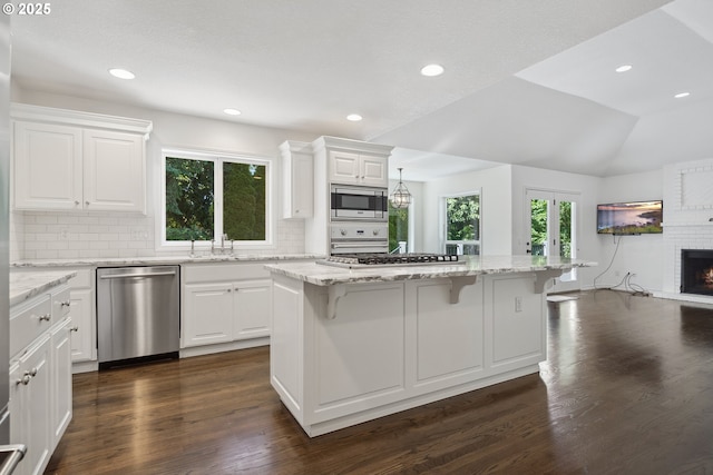 12723 Adrian Ct, Lake Oswego, OR 97034 - kitchen featuring stainless steel appliances, a breakfast bar, decorative backsplash, white cabinets, and recessed lighting