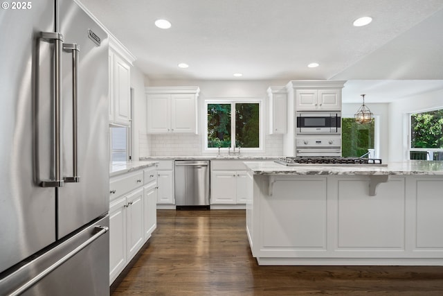 12723 Adrian Ct, Lake Oswego, OR 97034 - kitchen featuring appliances with stainless steel finishes, a breakfast bar area, backsplash, white cabinets, and recessed lighting